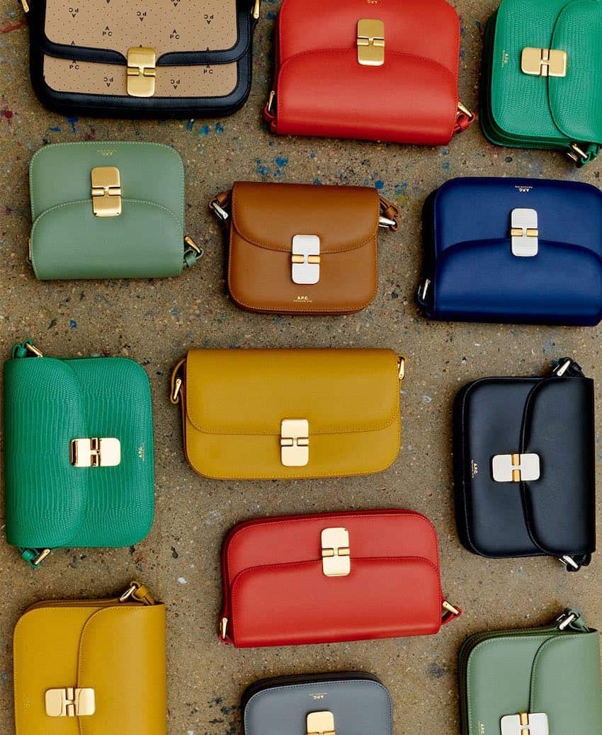 Multi-color purses laid out on a concrete floor.