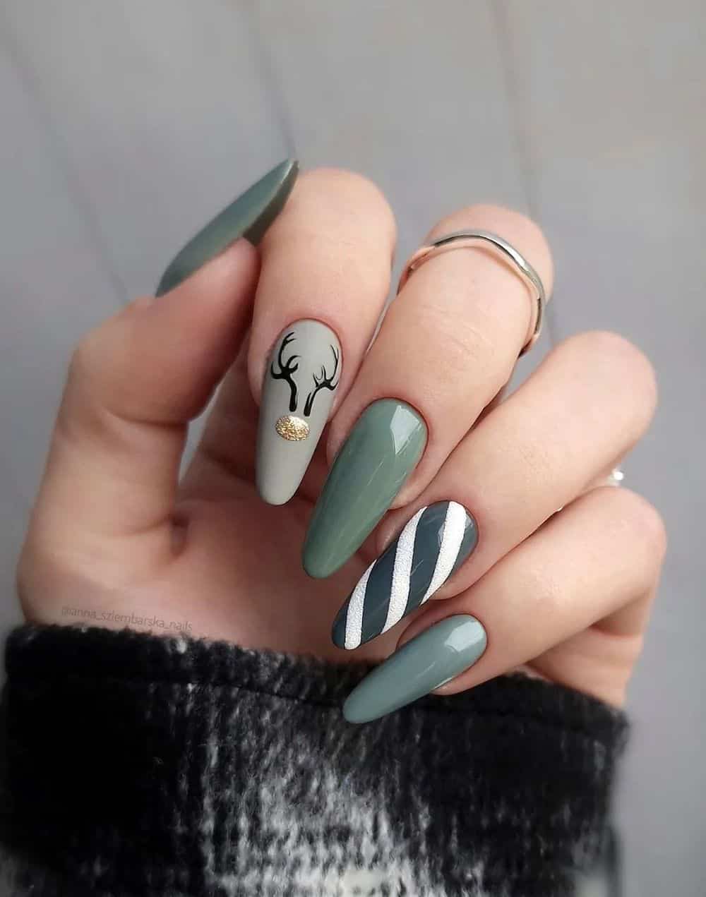 image of a hand with gradient sage green nails with white winter designs