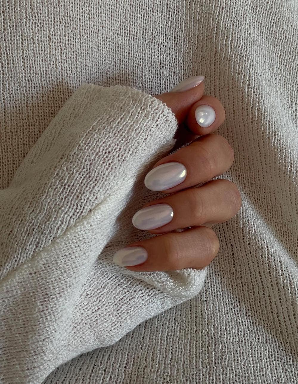 image of a hand with vanilla white chrome nails for winter