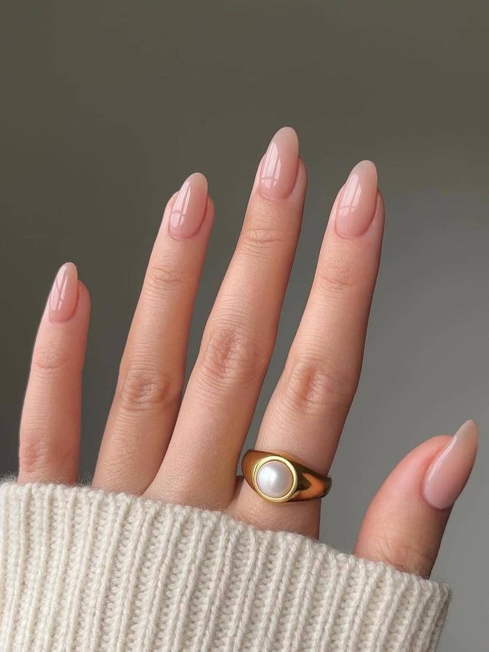 A hand with short nude almond nails