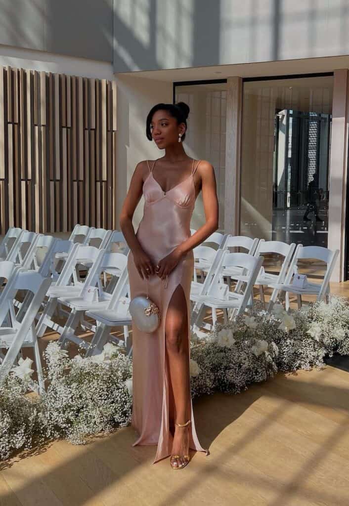 Black woman wearing a pink slip dress at a Spring wedding