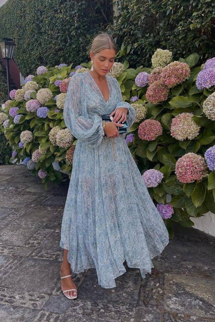 woman at a spring wedding wearing a blue floral long sleeve maxi gown