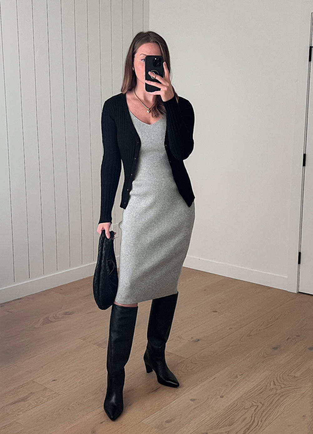 Christal wearing a grey sweater dress with tall black boots and a black cardigan.