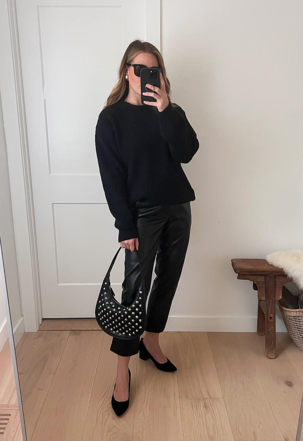 Christal wearing black leather pants with black heels and a black sweater.