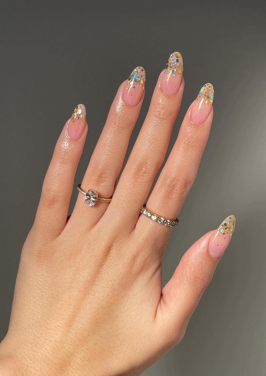 Medium nude pink almond nails with chunky glitter ombre tips