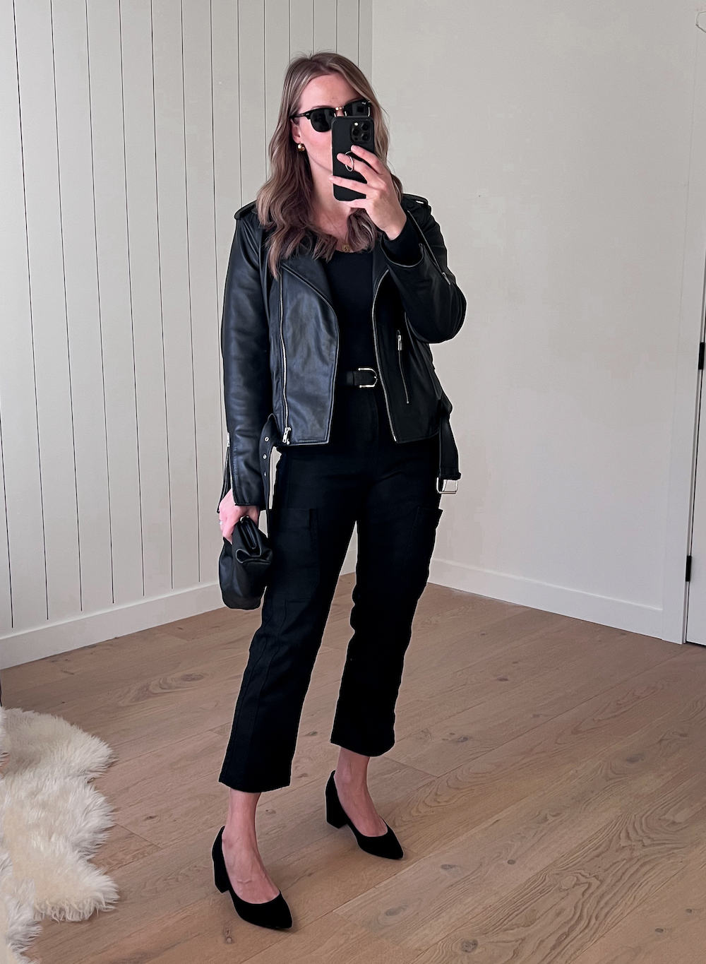 Christal wearing black pants, a black tank top and a black leather jacket with block heels.