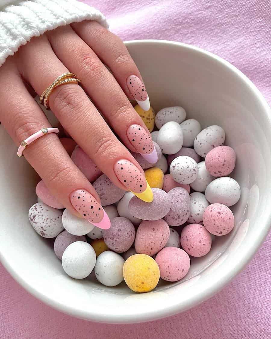 Long nude almond nails with pastel tips and black speckles