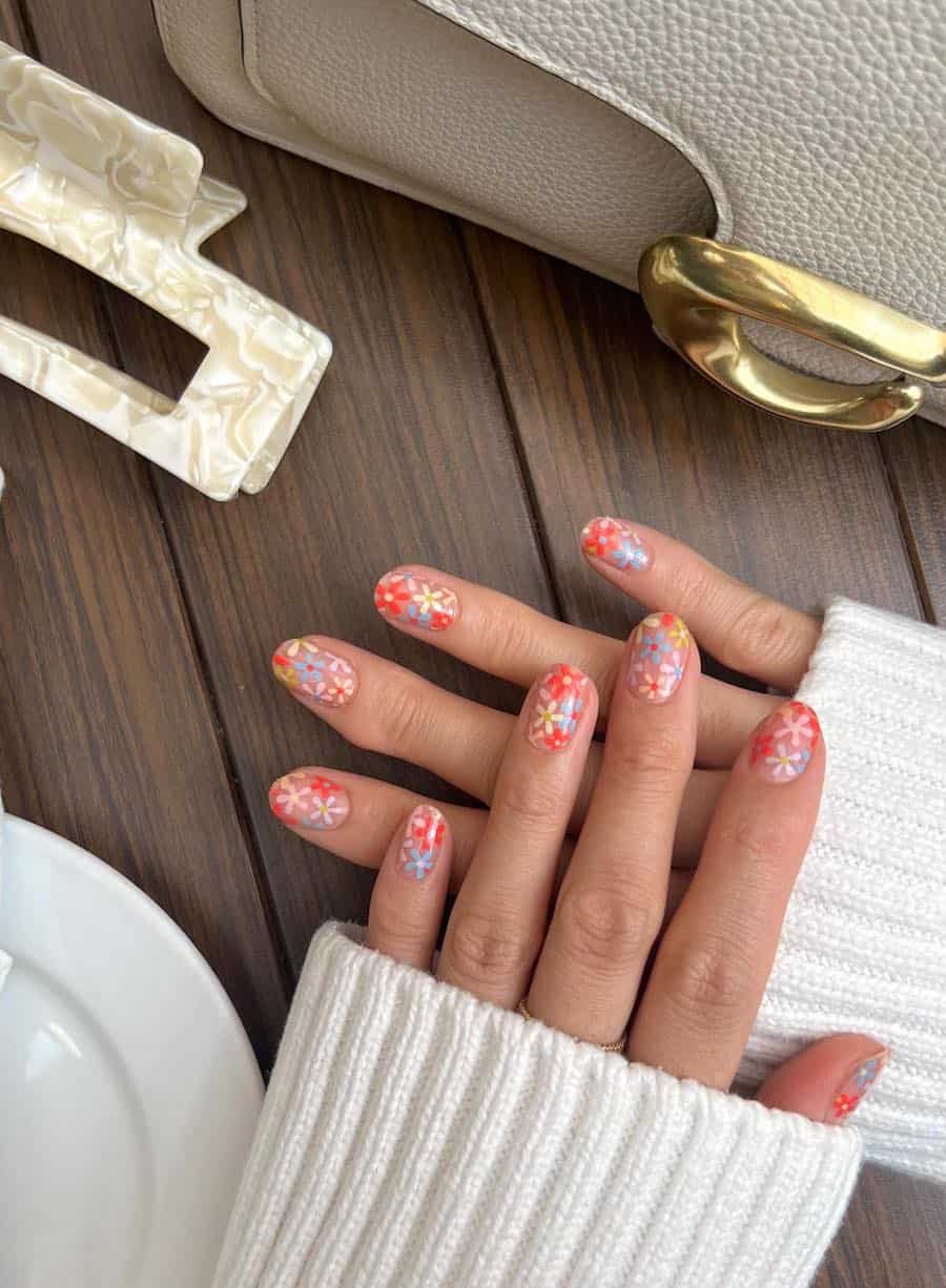 Short nude round nails with orange, yellow, pink, and blue retro flowers