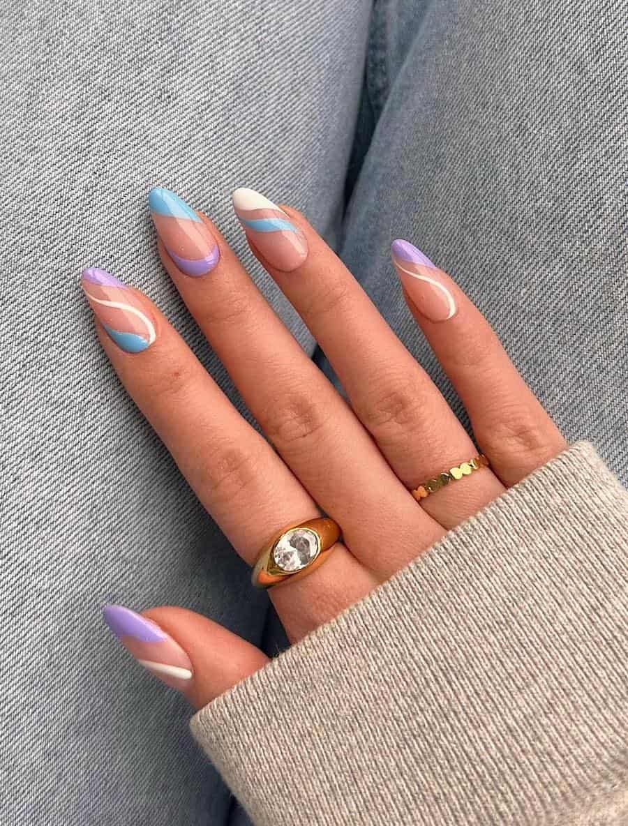 Medium nude almond nails with white, light blue, and light purple waves