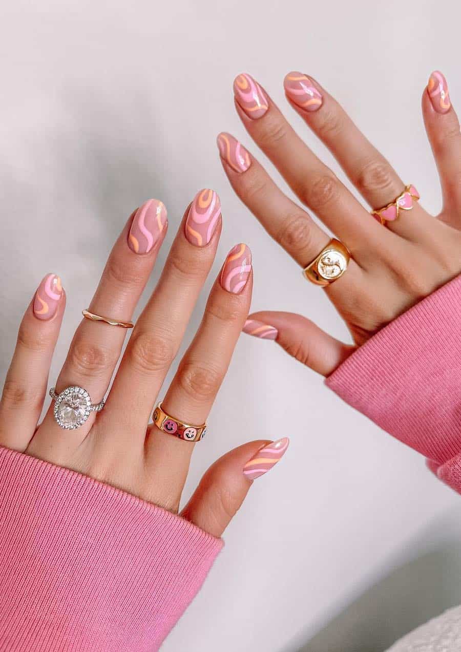 Short round nude nails with light pink and light orange swirls