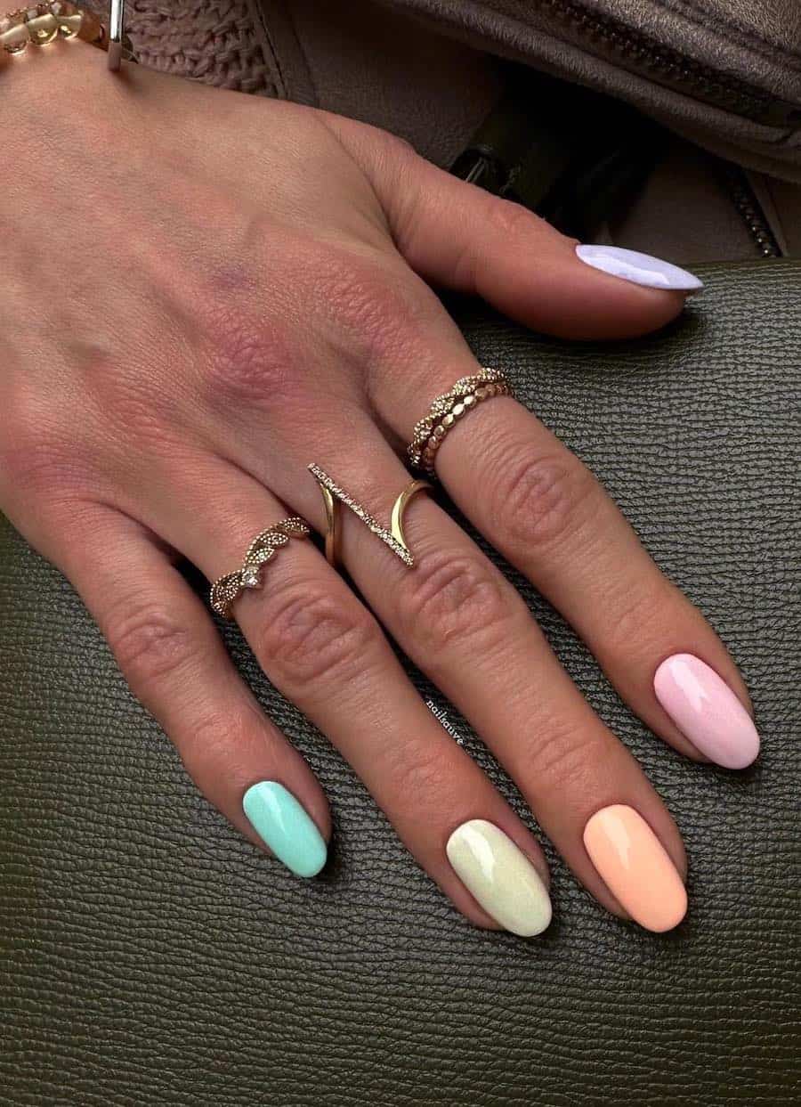 Short round nails painted a rainbow pastel gradient