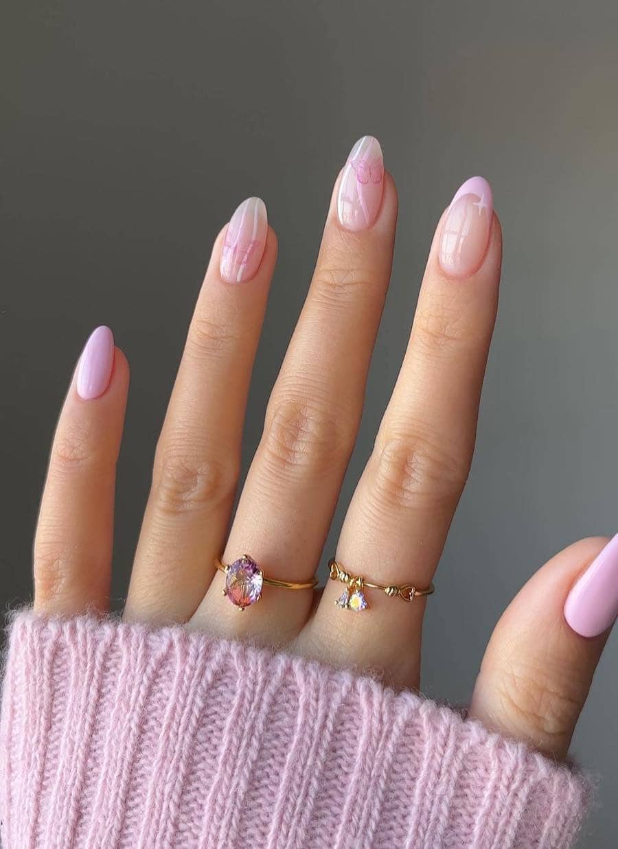 Short nude almond nails with light pink solid-colored nails, a light pink tip accent nail, and two nude accent nails with pink swirls and butterfly nail stickers