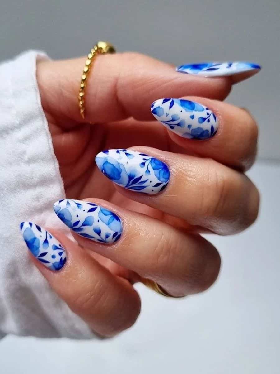 Medium white almond nails with blue glazed porcelain nail art