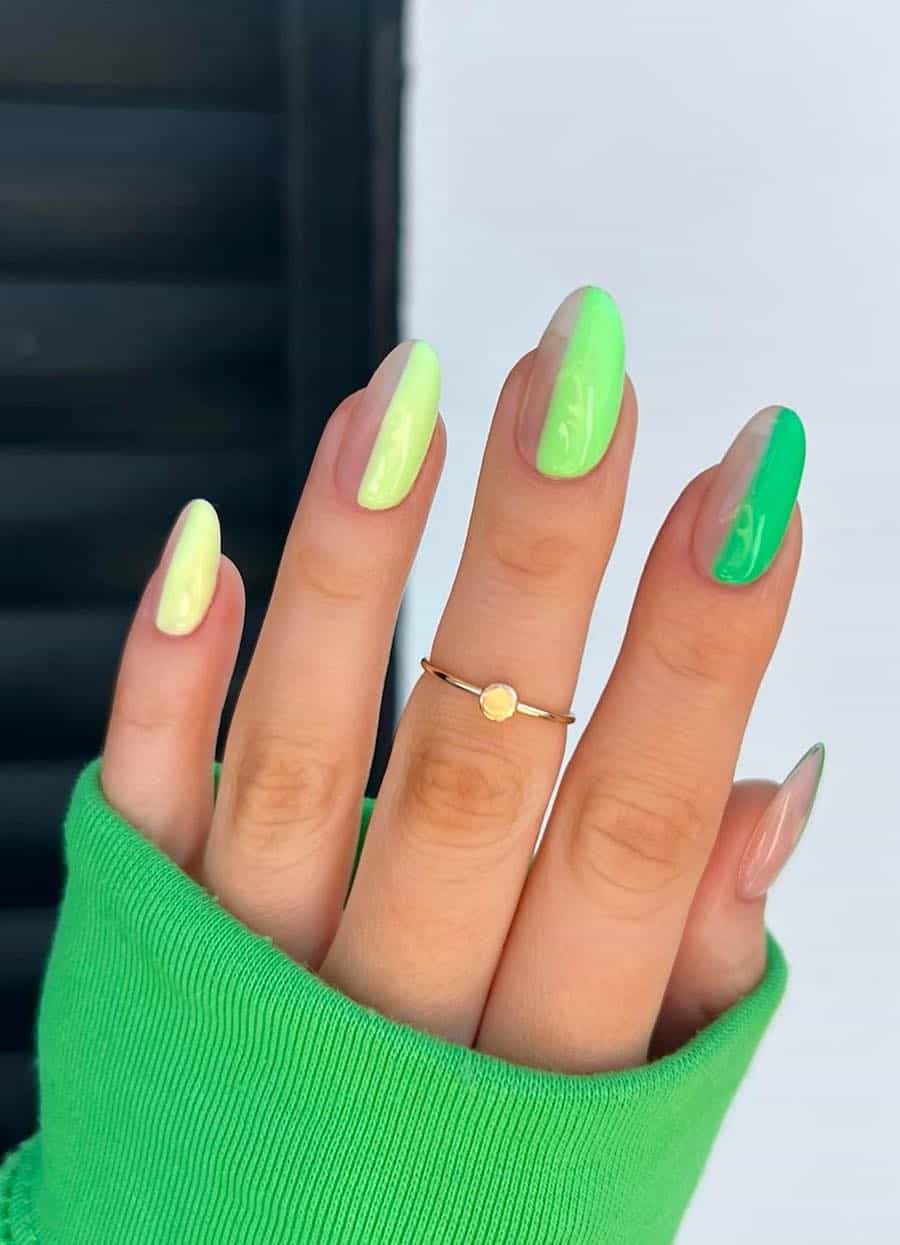 Medium almond nails that are half nude and half color featuring gradient yellow and green shades