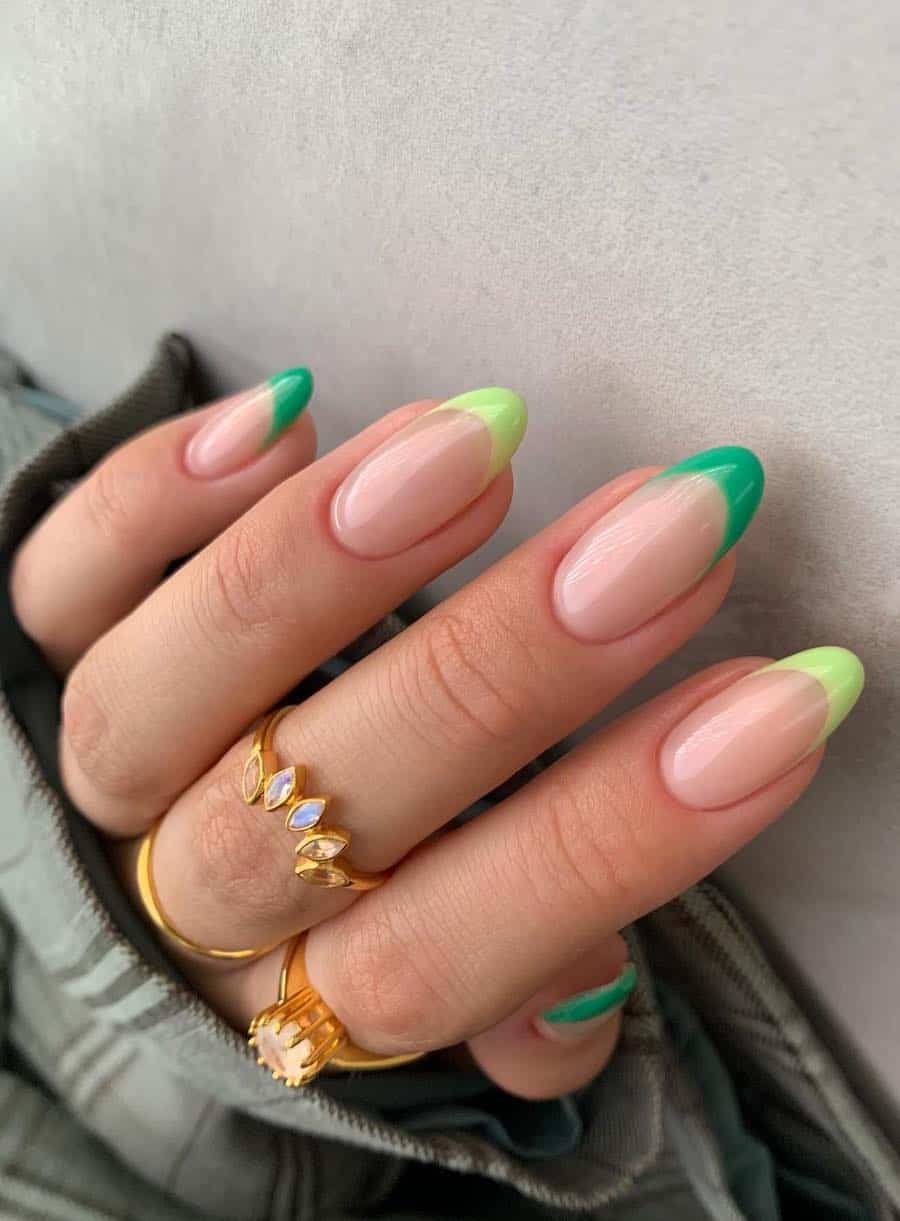 Medium-length nude almond nails with alternating light and medium green tips