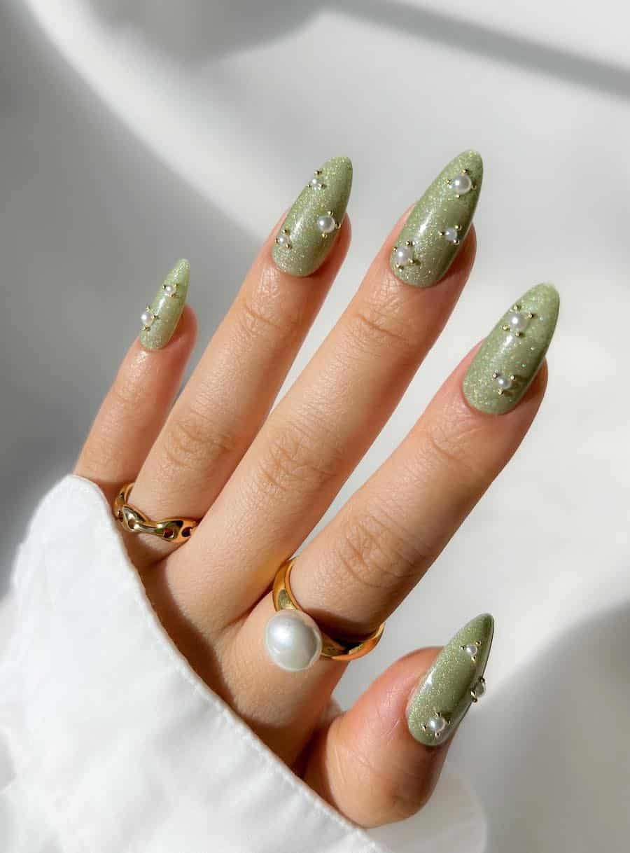 Long shimmering light green almond nails with gold beads and pearls