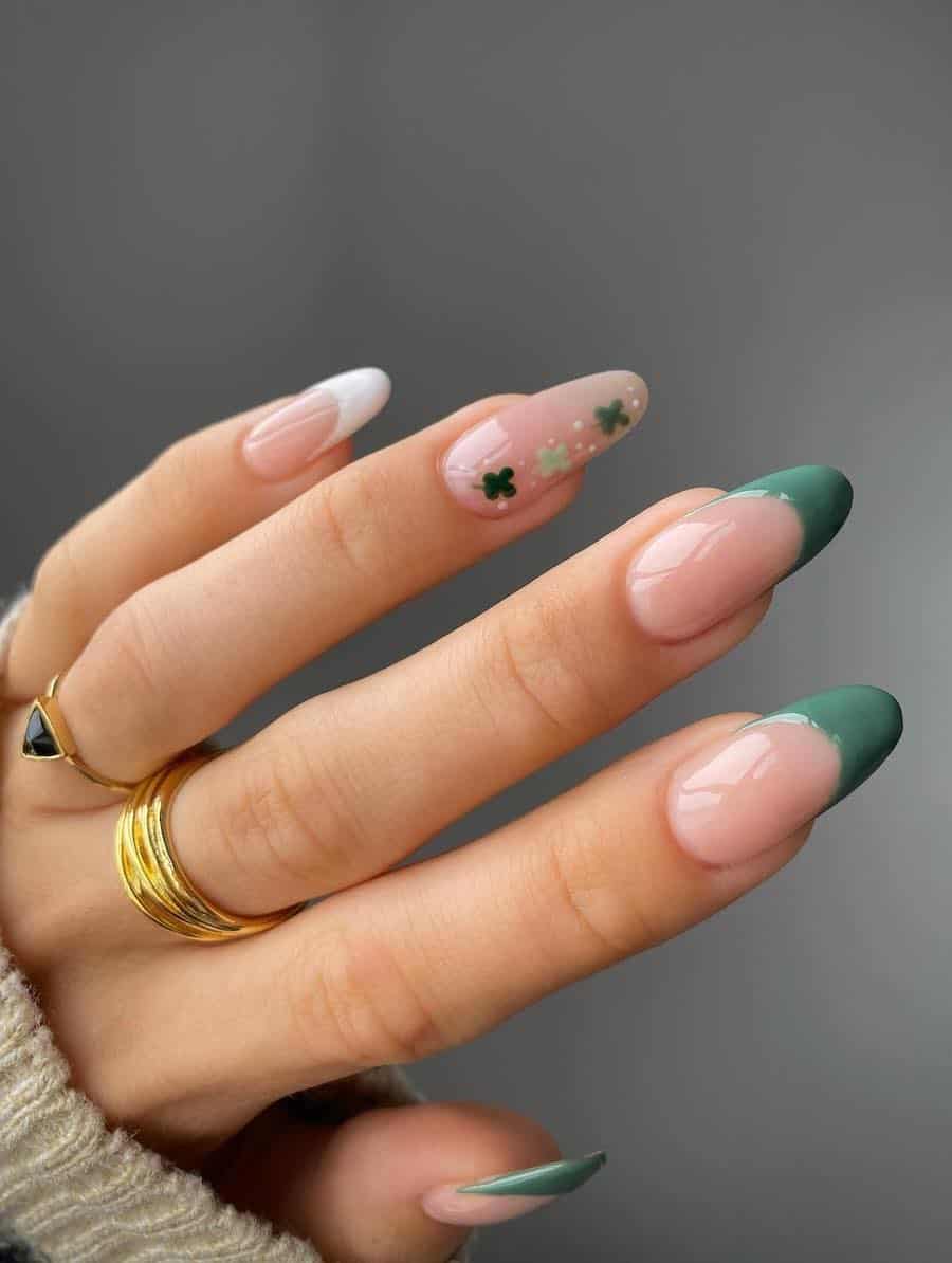 Long nude almond nails with white and green French tips and a plain nude accent nail with clover nail art