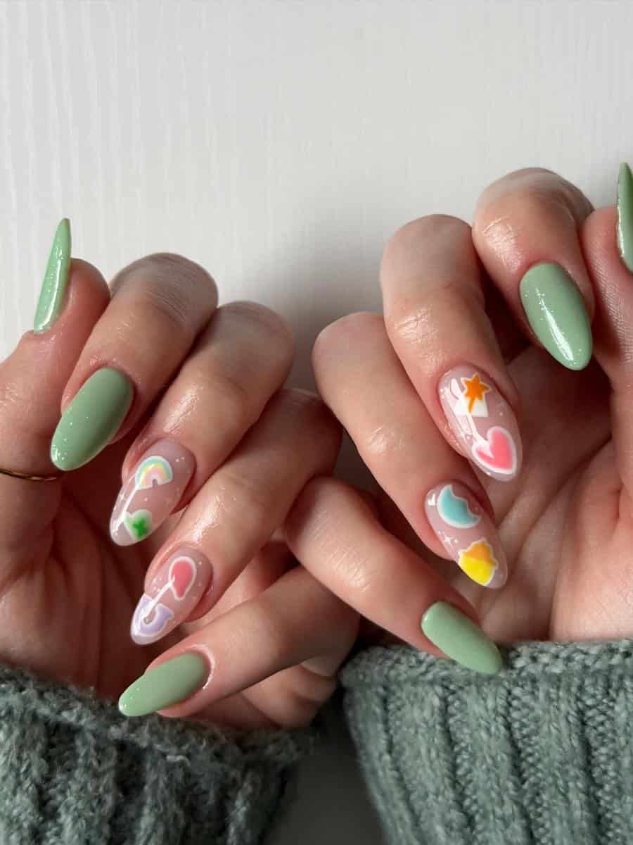 Long light green almond nails with nude accent nails featuring lucky charm nail art