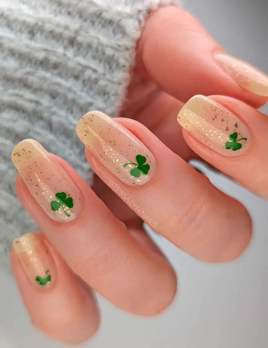 Medium nude squoval nails with gold glitter and green three leaf clovers