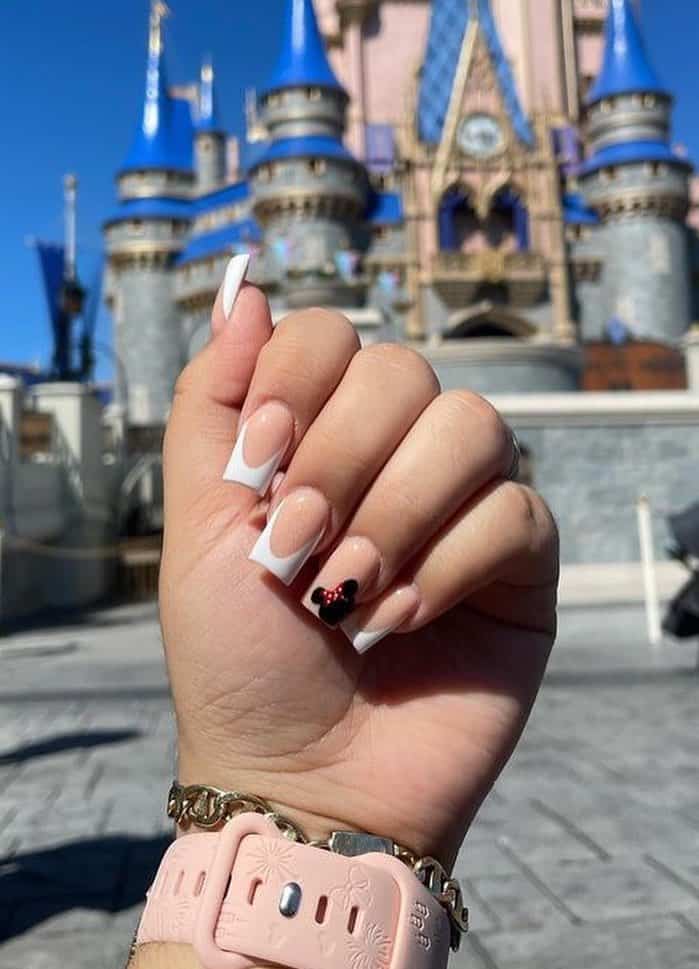 Medium square nails with a Minnie Mouse design featuring nude polish and white tips