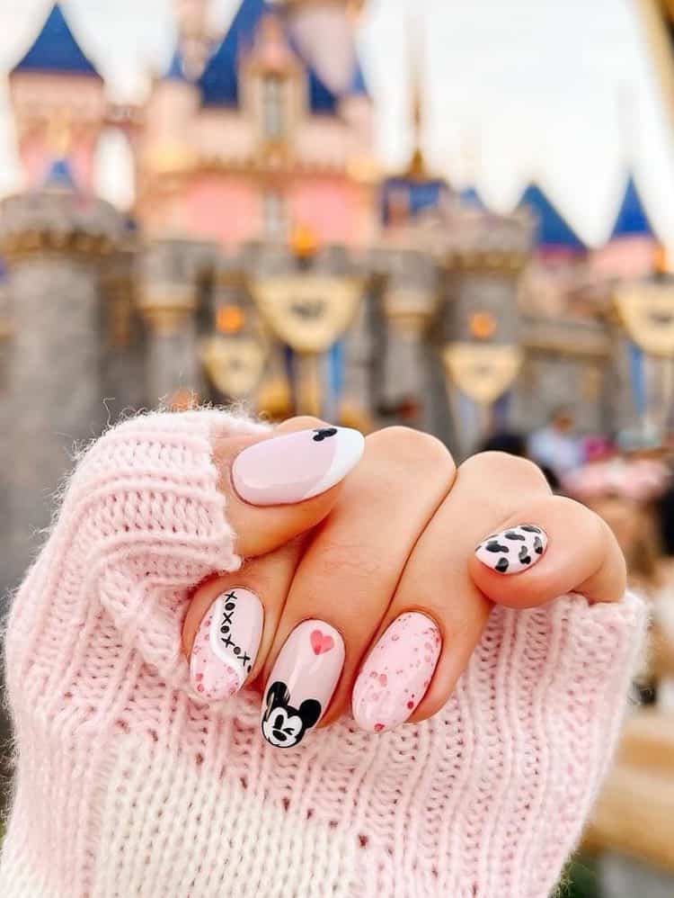 Medium almond nails with a Mickey Mouse design featuring soft pink polish, black and white nail art, and red hearts