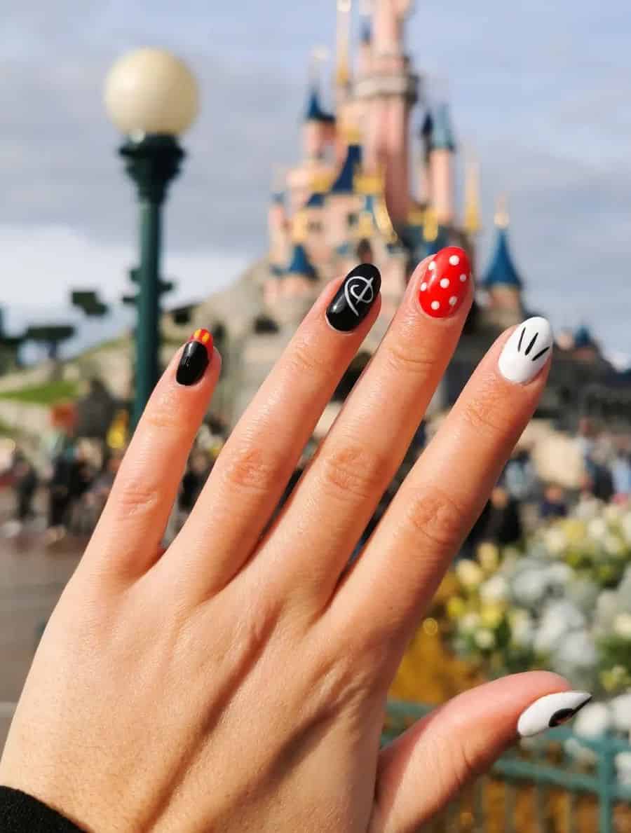 Short round nails with a Disney collage design featuring red, black, and white polish