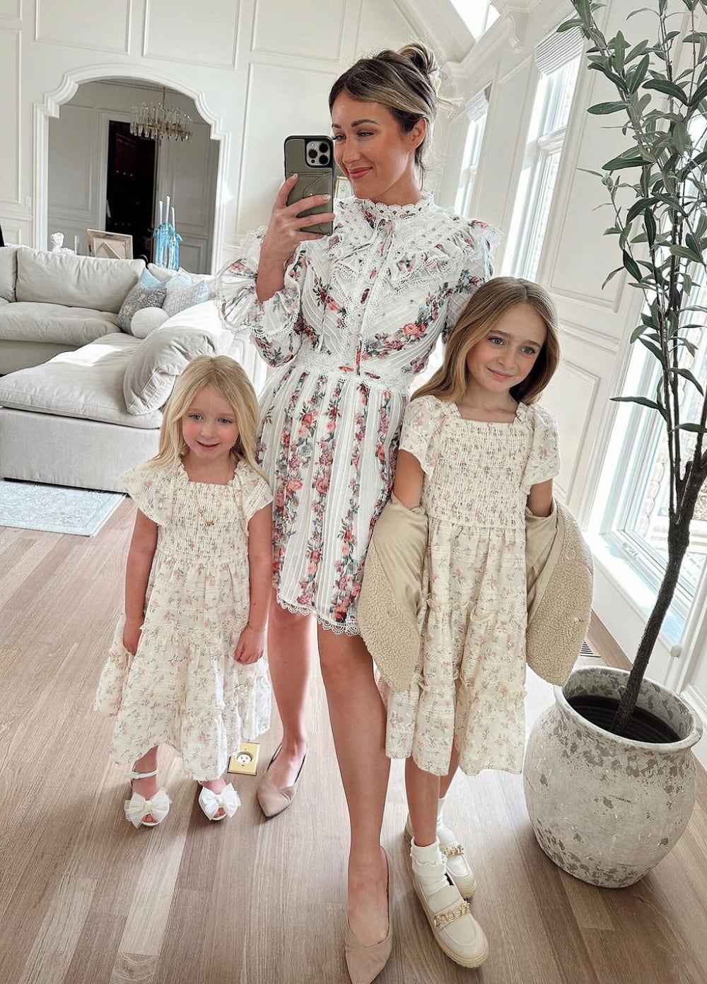 Woman and two daughters wearing white and floral Easter dresses.