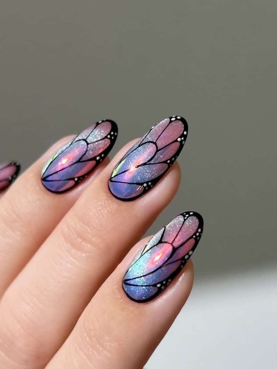Long round nails painted in shimmering pink and blue with fairy wing art