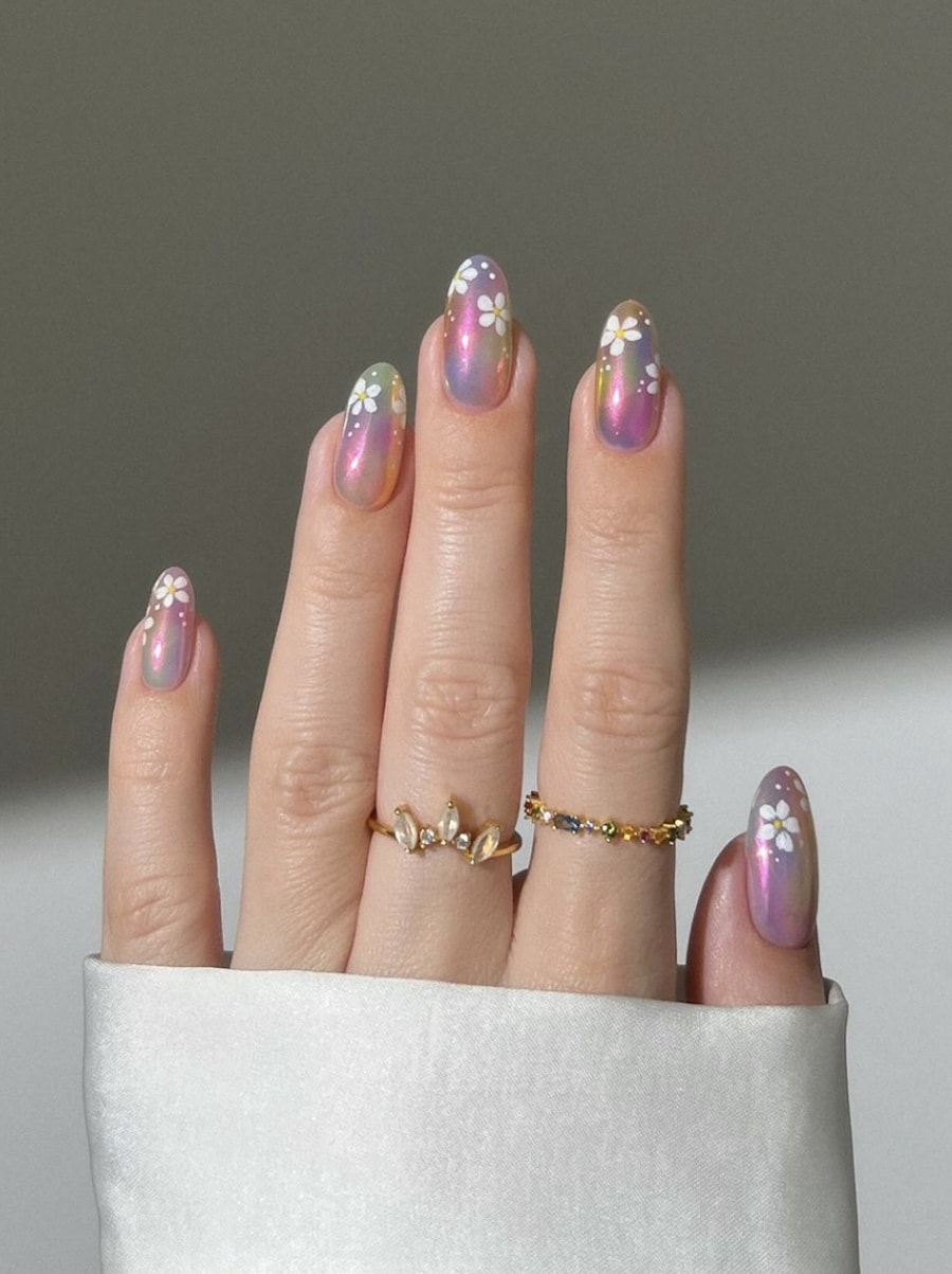 Medium round nails with iridescent chrome polish and white floral details