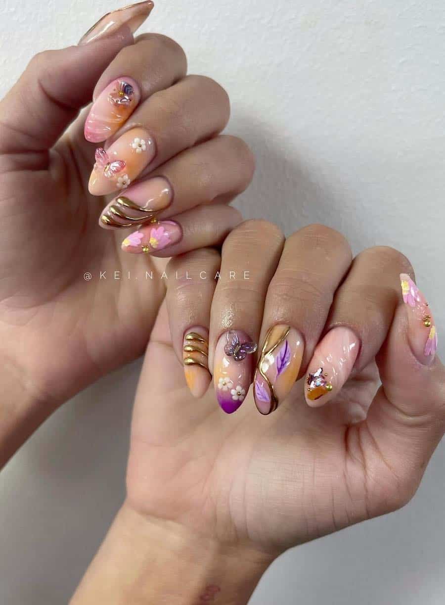 Medium almond nails painted a soft peach color with pops of pink, purple, and orange with floral and fairy core details