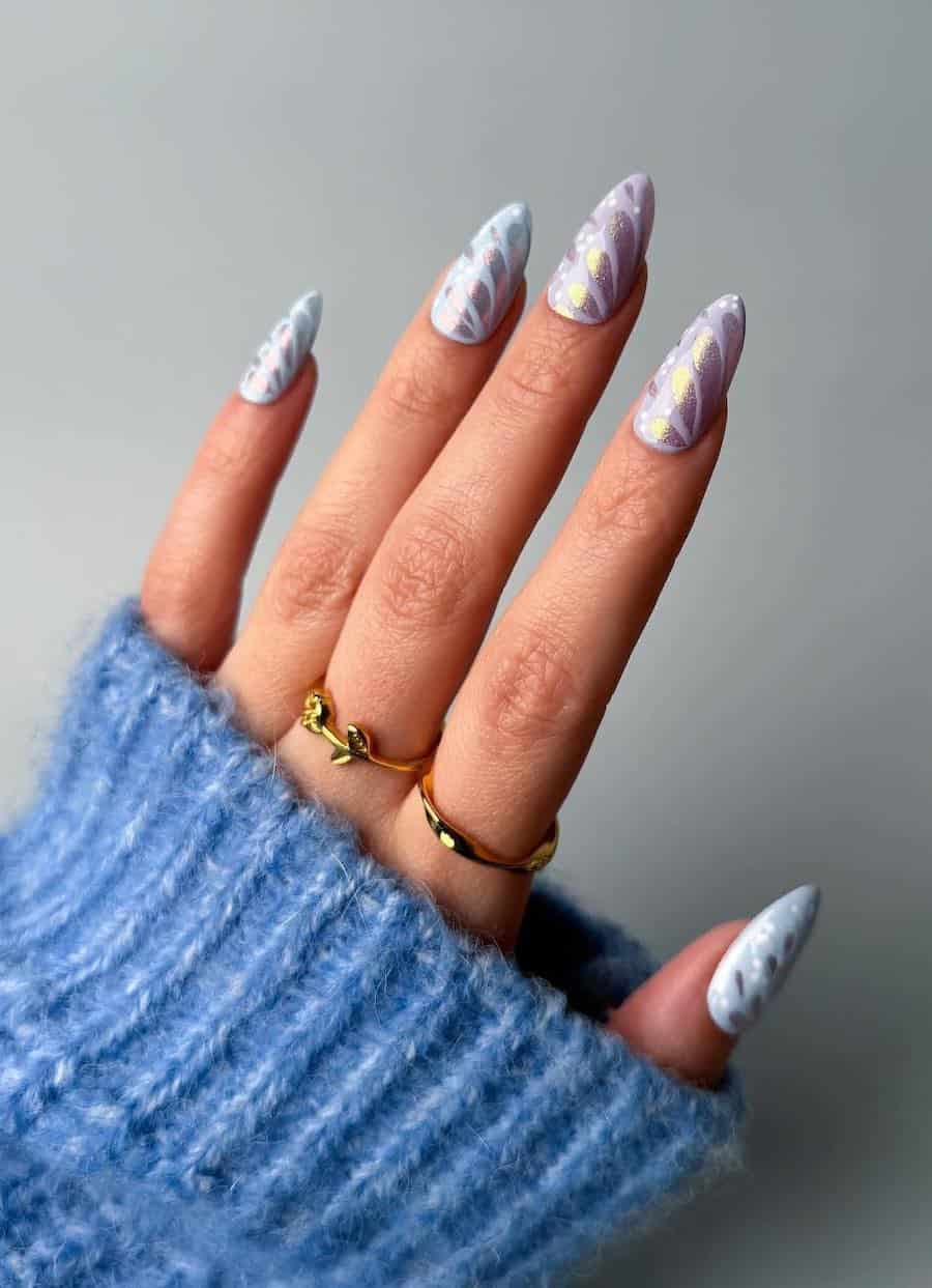 Long almond nails with pastel pink and blue polish and silver butterfly wing designs