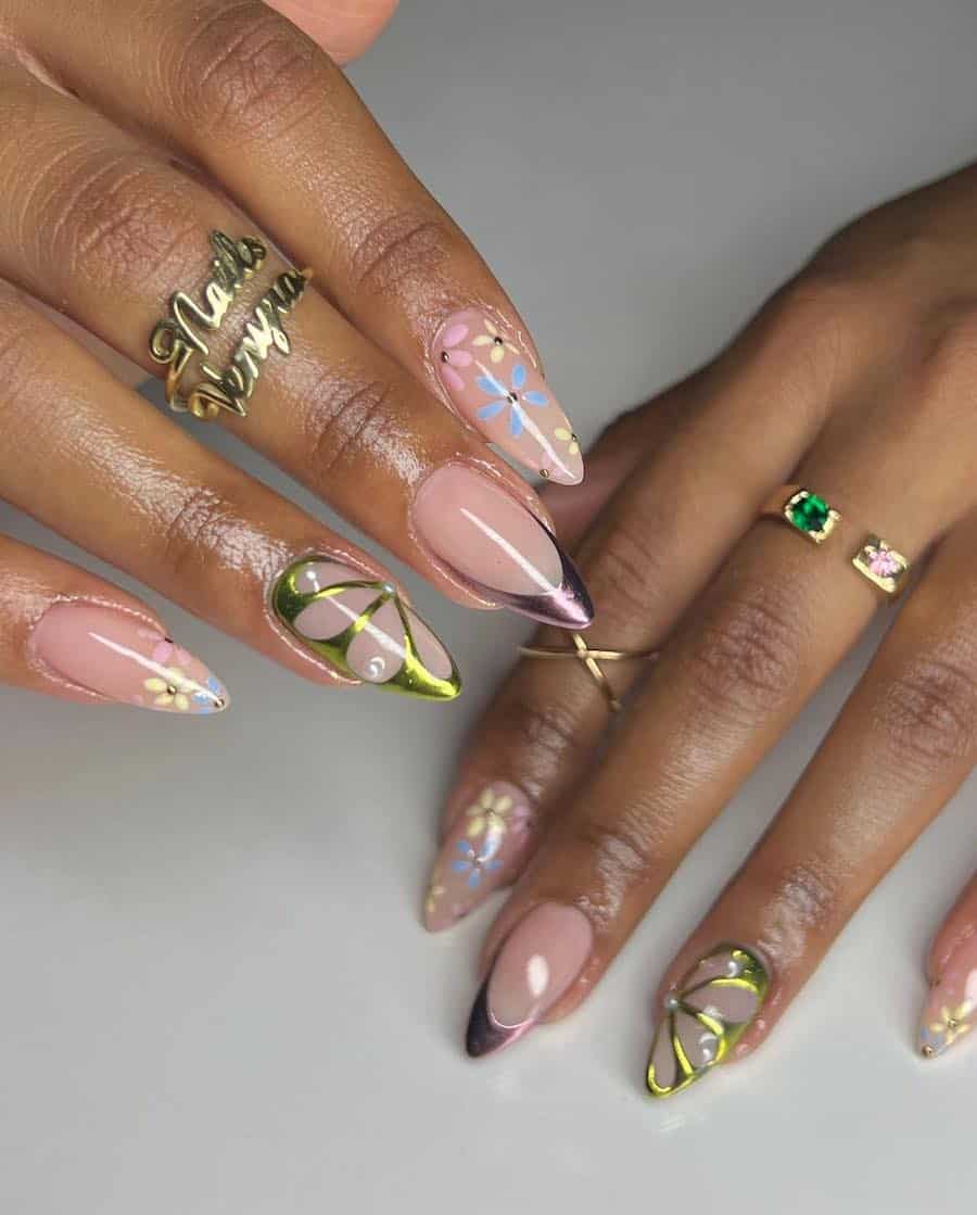 Medium almond nails with glossy nude polish, green chrome butterfly wing accents, pastel floral art, and purple chrome tips