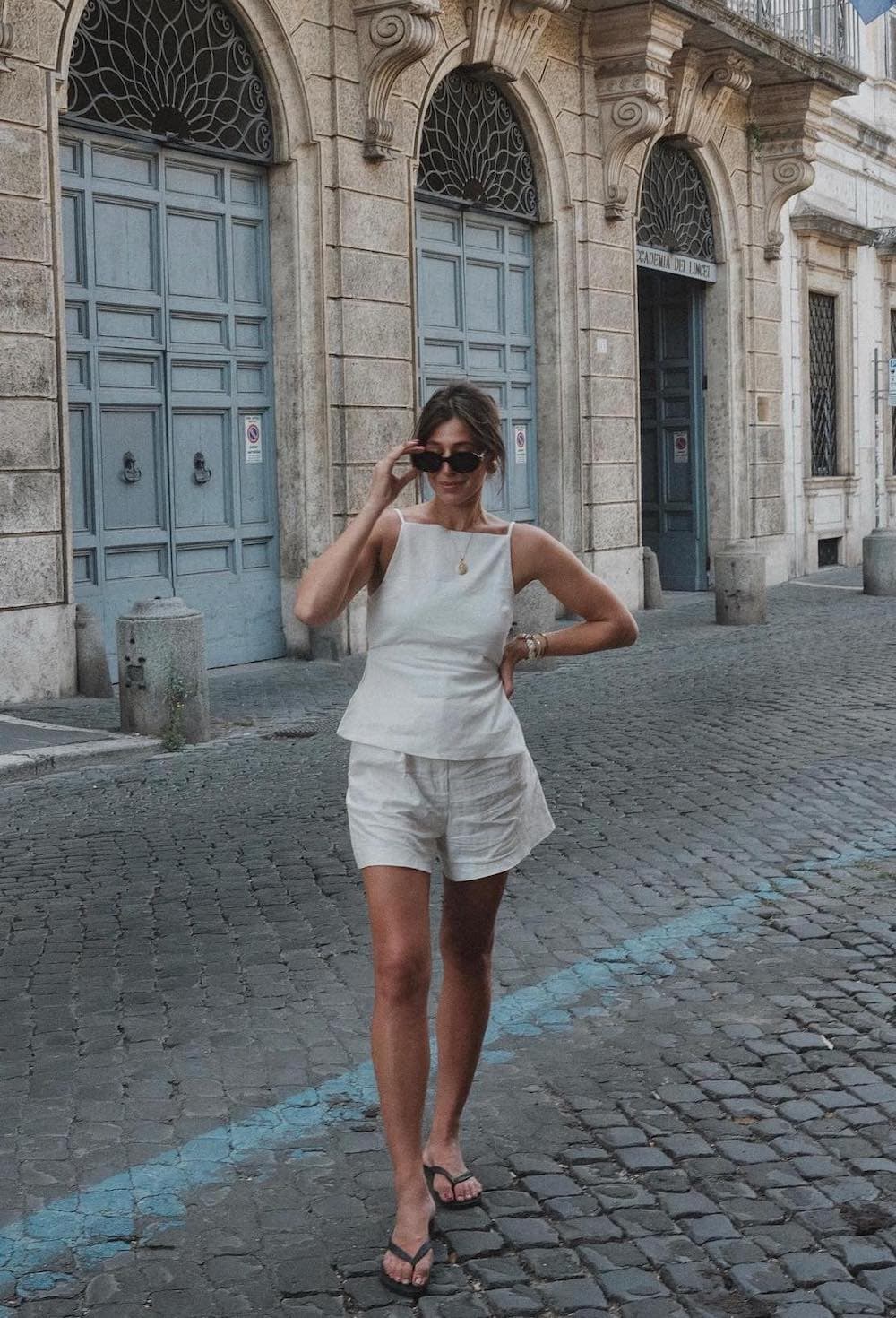 Woman wearing an oatmeal colored linen short set with sandals.