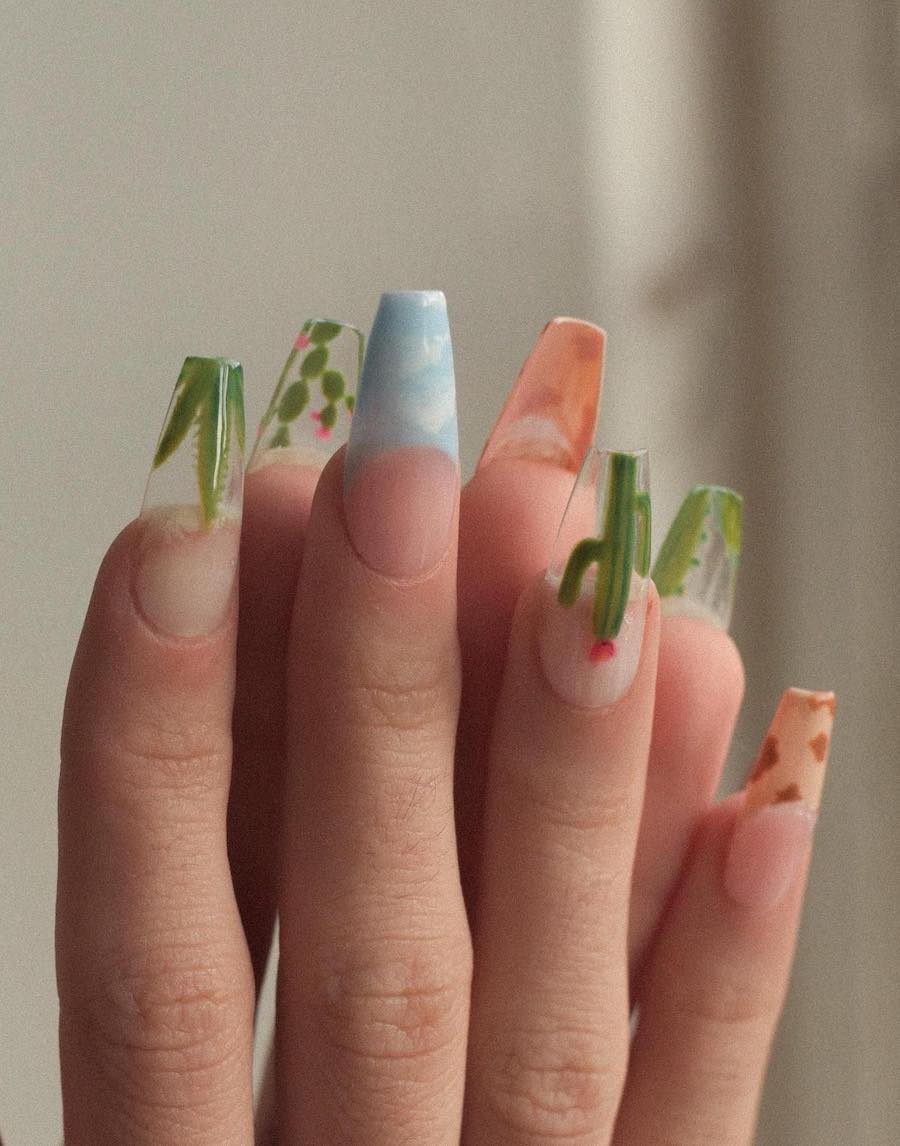 Long nude coffin nails featuring cactus nail art, blue sky tips, and cow print tips