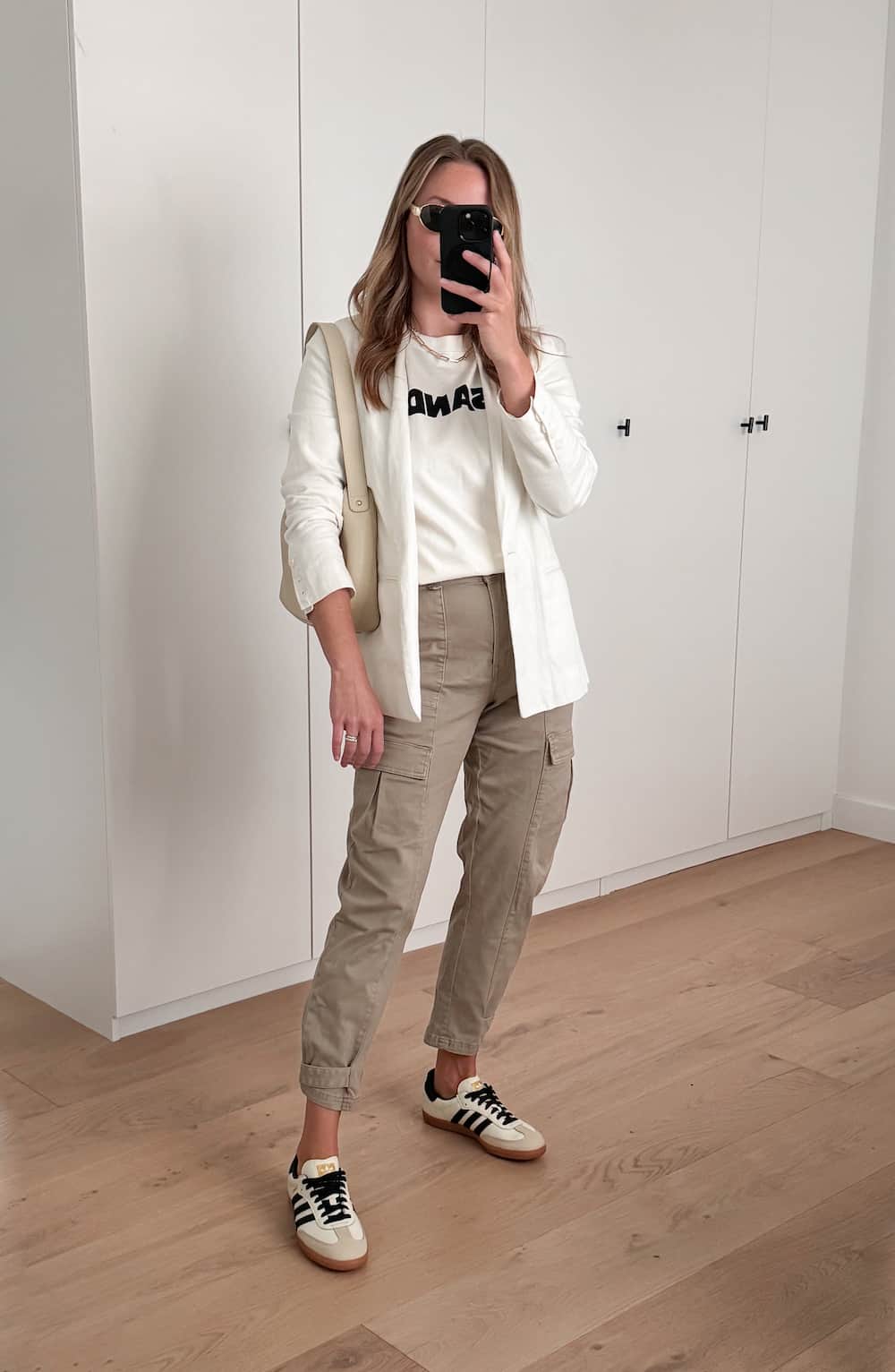 Christal wearing cargo pants, sneakers, a graphic tee and a white blazer.