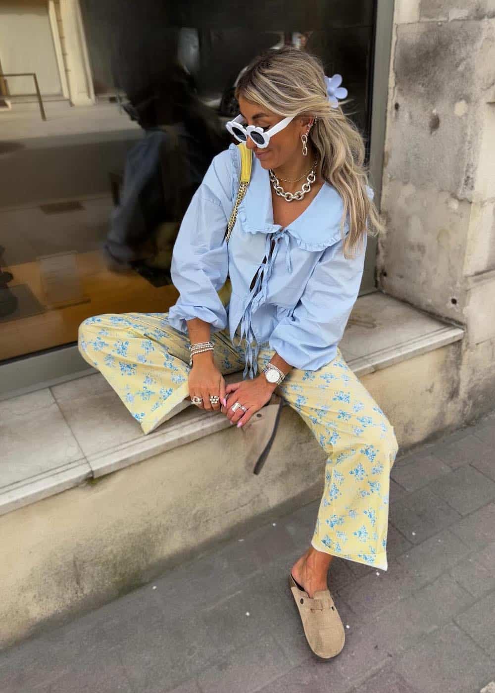 a woman wearing a sky blue front tie blouse with yellow floral pants