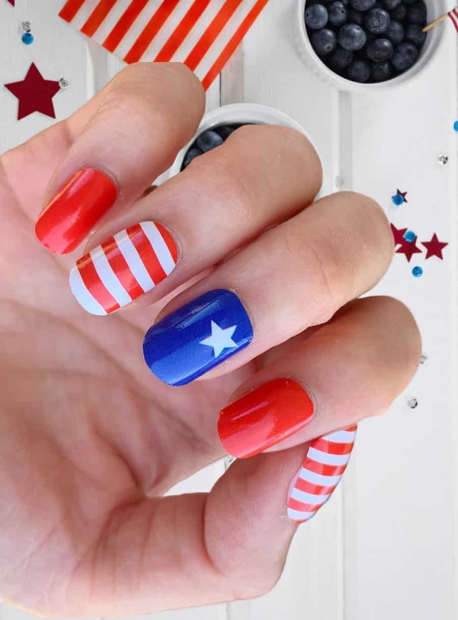 short nails with red polish, red and white striped nails, and blue nails with a white star