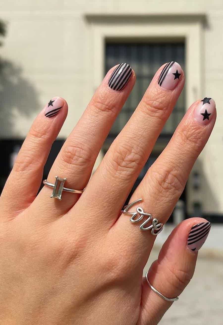 short nude round nails with black stripes and stars