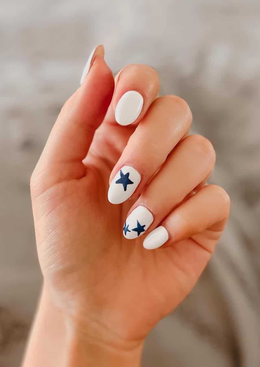 medium white almond nails with navy blue star accent nails