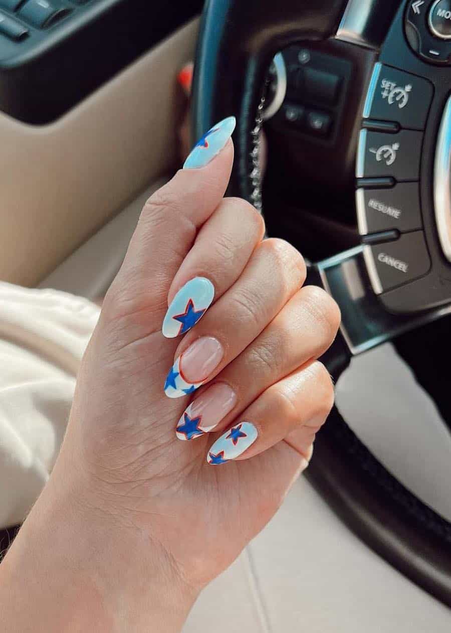 long almond white almond nails with blue and red stars and two French tip accent nails with star details