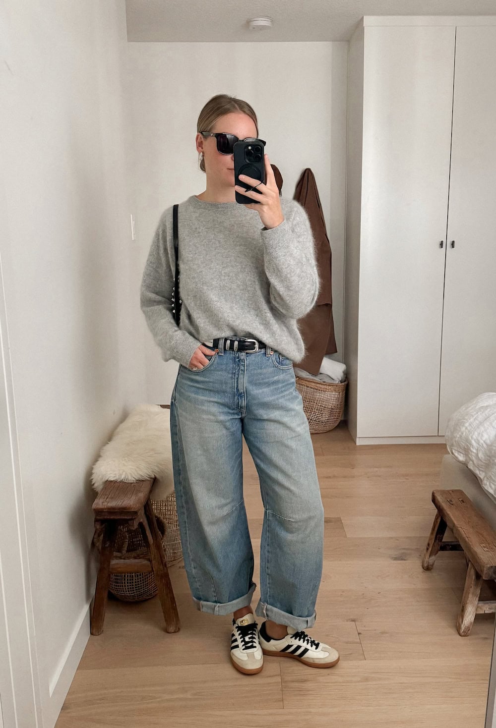 Christal wearing baggy ankle jeans, sneakers and a grey sweater.