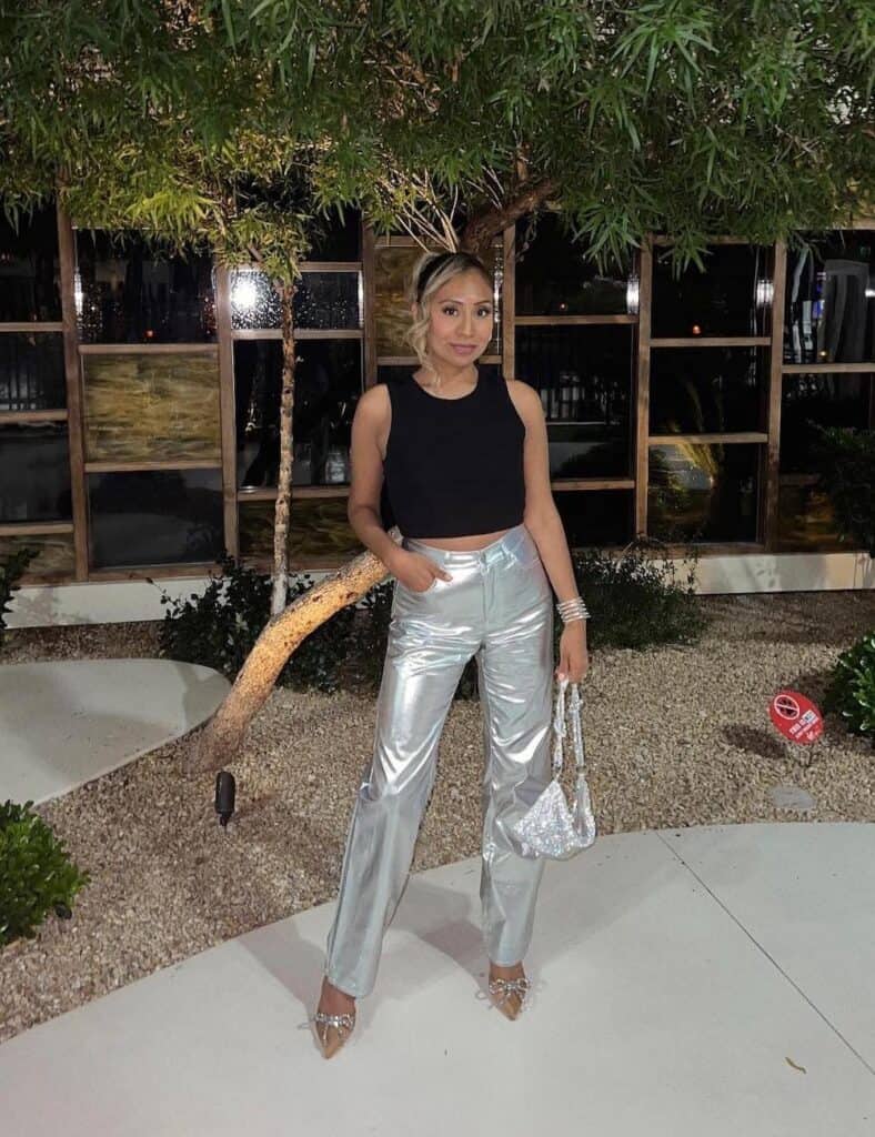 woman wearing a black tank top with metallic silver pants and heels
