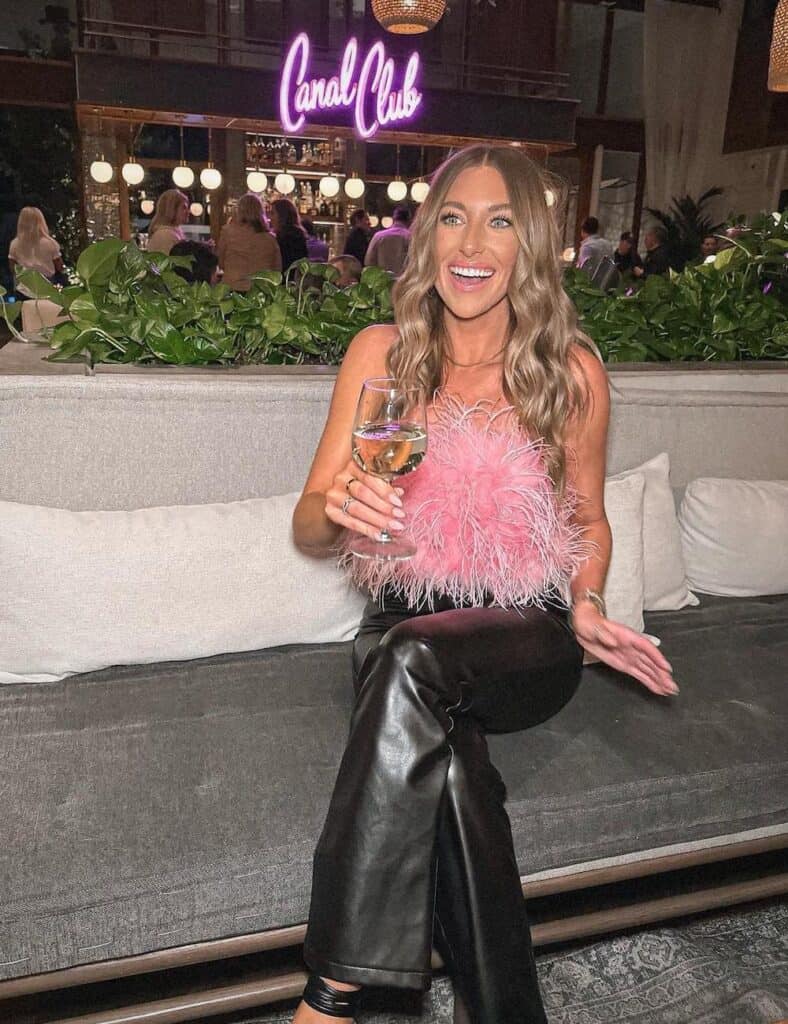 woman wearing a pink feather tube top with black leather pants