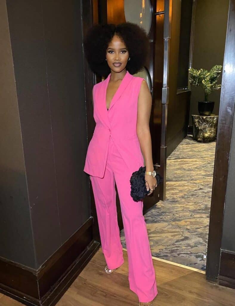Black woman wearing a two piece hot pink suit and heels