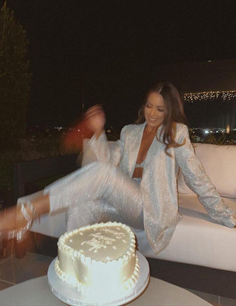woman wearing a silver glitter pant suit with silver heels at her birthday
