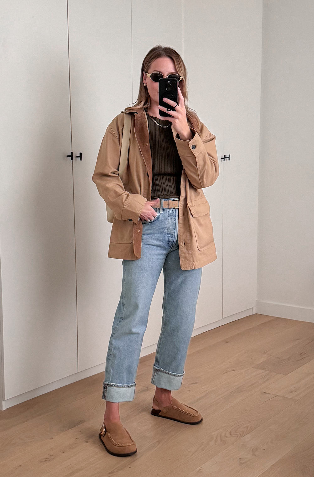 Christal wearing jeans, a brown top, a tan utility jacket and Ugg shoes.