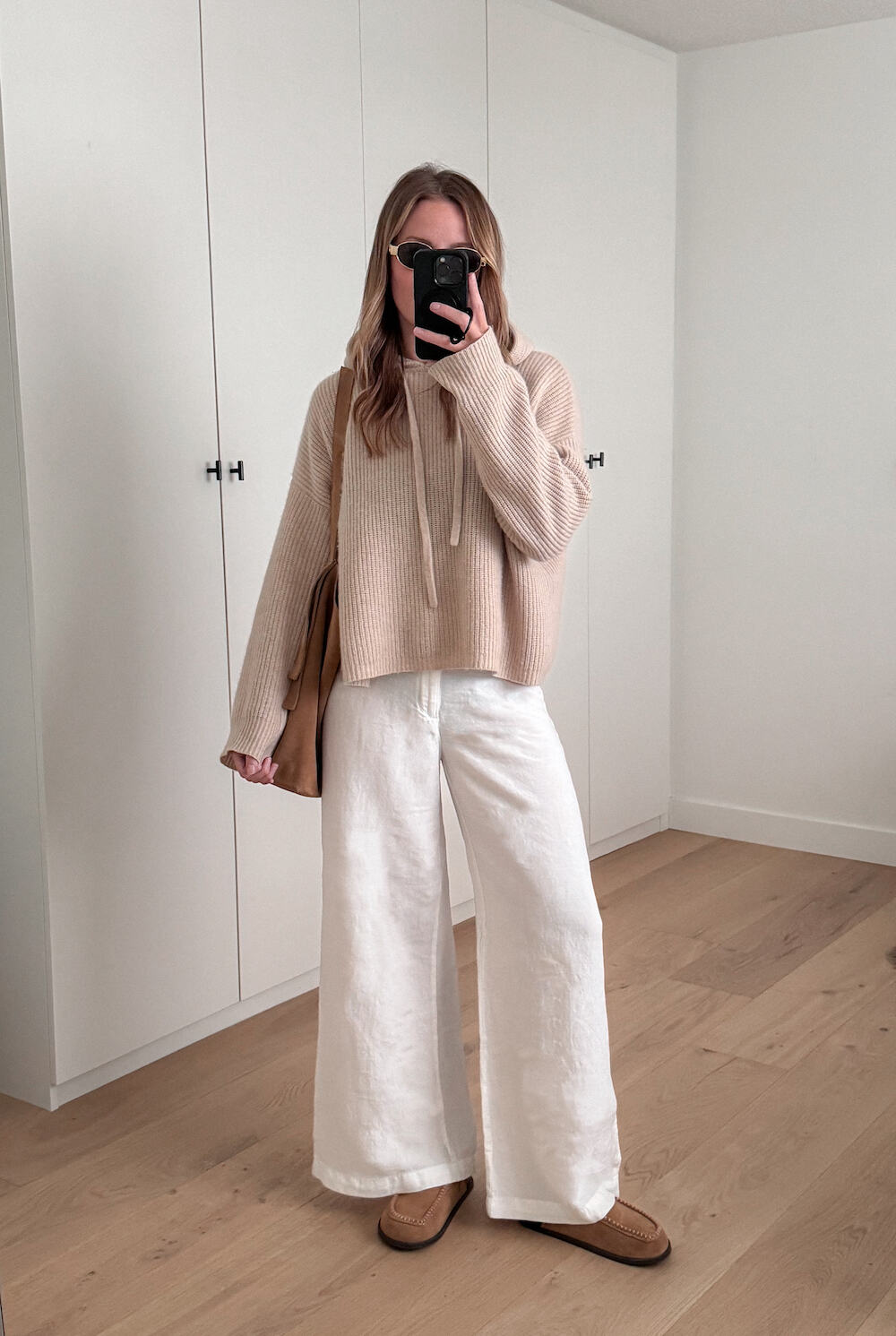 Christal wearing white wide leg jeans and a beige oversized sweater.
