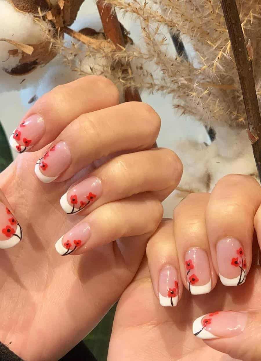 short nude squoval nails with white tips and red poppy nail art
