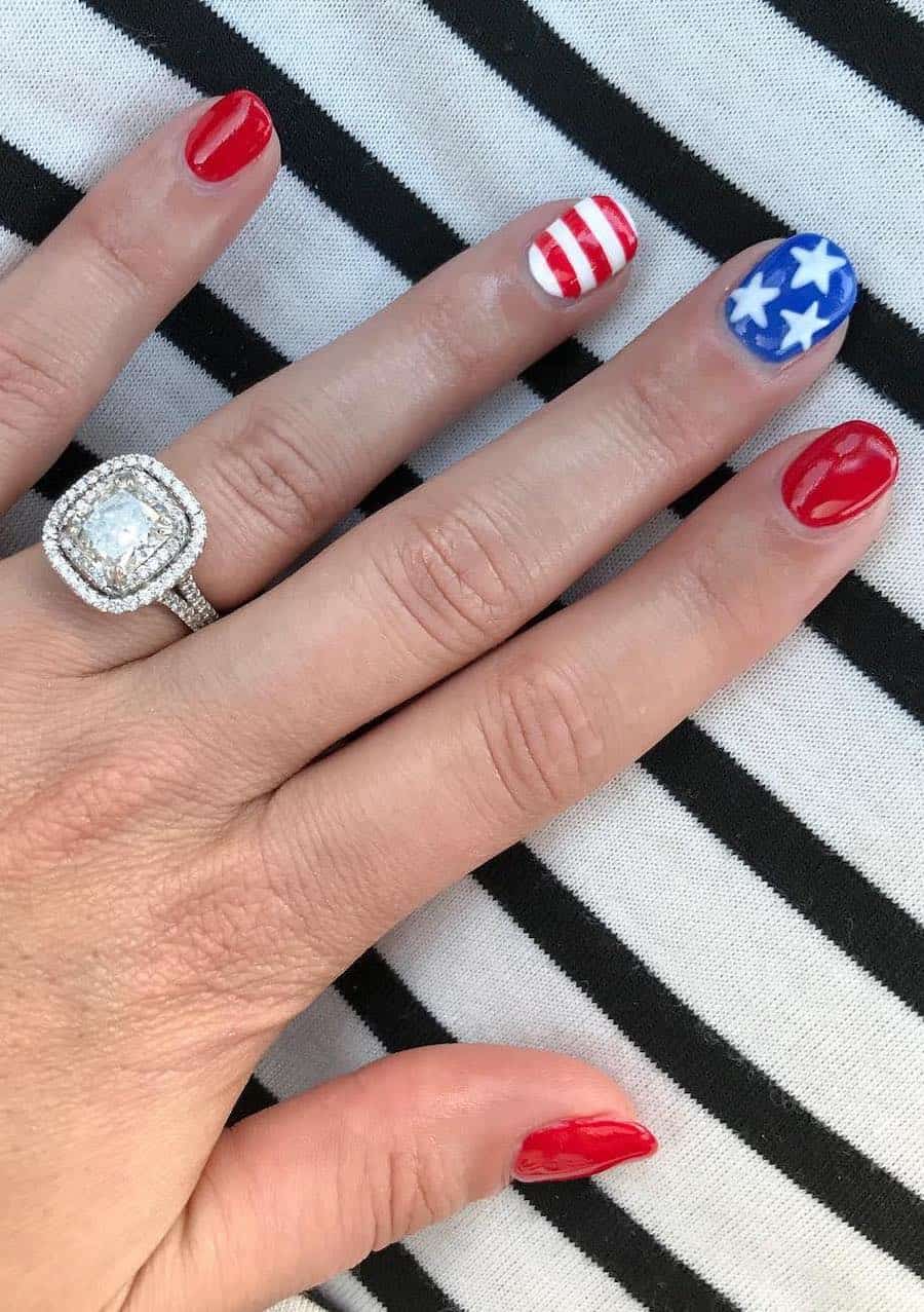 short round nails painted with red polish and accent nails featuring red and white stripes and blue polish with white stars