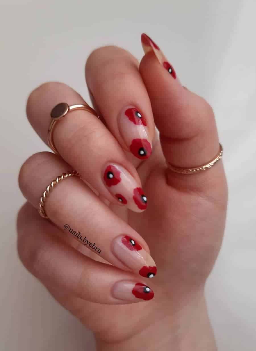 long nude almond nails featuring red poppy nail art